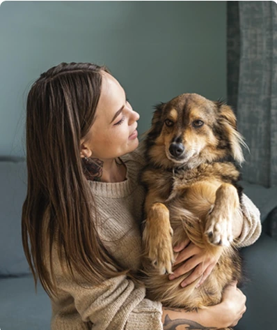A small dog cuddled by its owner